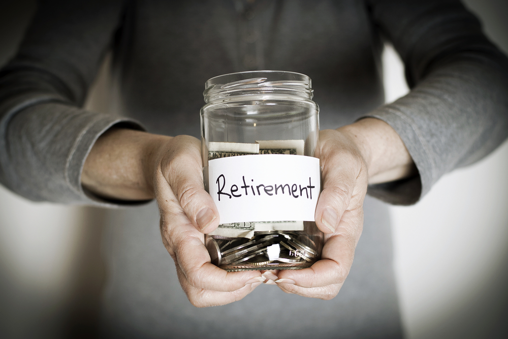 Person holding retirement savings jar